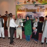 Dr. Din Muhammad receiving shield from Speaker Assembly